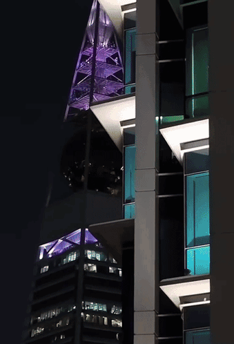 A Tall Building With A Purple Roof And A Green Roof GIF
