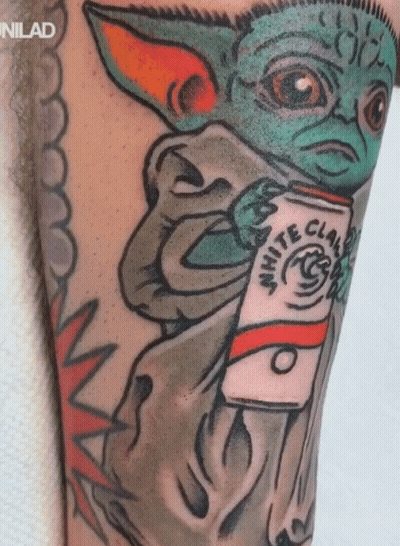 A Tattoo Of A Baby Yoda Holding A White Claw Coffee GIF