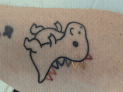 A Tattoo Of A Dinosaur With A Rainbow Tail On A Person 'S Arm GIF