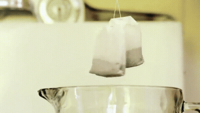 A Tea Bag In A Measuring Cup With A Label That Says Raspberry GIF