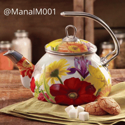 A Teapot With Flowers Painted On It Sits On A Table GIF