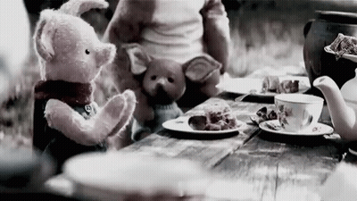 A Teddy Bear And A Pig Are Sitting At A Table With Plates Of Food . GIF