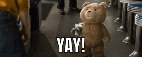 A Teddy Bear In A Diner Holding A Cup That Says Yay GIF