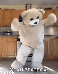 A Teddy Bear Is Dancing In A Kitchen In A Costume . GIF