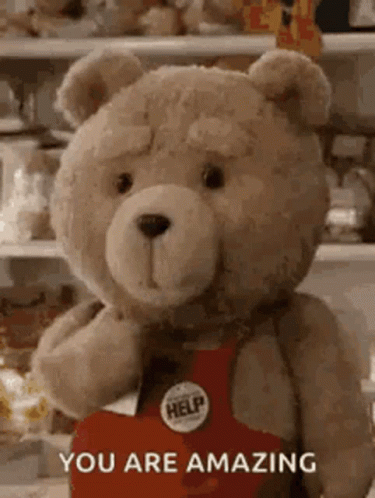 A Teddy Bear Is Holding A Heart With The Words `` You Are Amazing '' Written On It . GIF