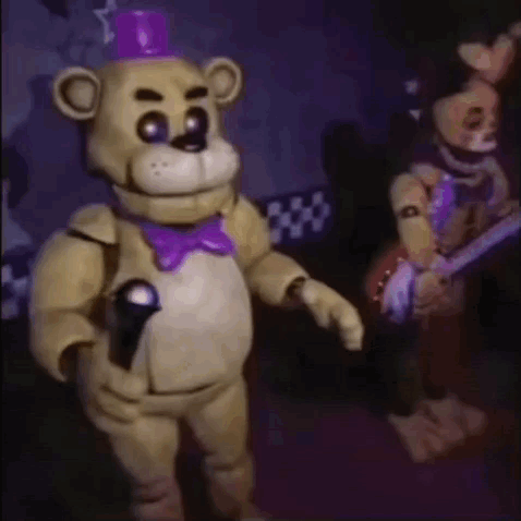 A Teddy Bear Is Holding A Microphone And Wearing A Purple Bow Tie . GIF