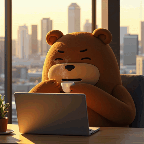A Teddy Bear Is Sitting At A Desk With A Laptop And A Cup Of Coffee GIF