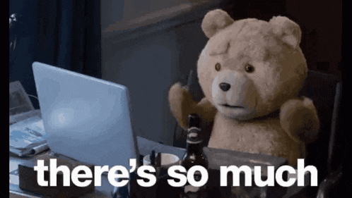 A Teddy Bear Is Sitting In Front Of A Laptop With The Words " There 'S So Much " Written Below It GIF