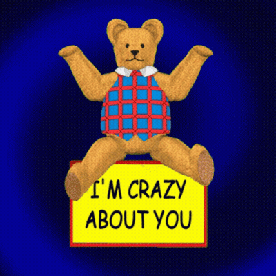 A Teddy Bear Is Sitting On A Yellow Sign That Says I 'M Crazy About You GIF
