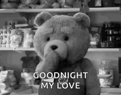 A Teddy Bear Is Standing In Front Of A Refrigerator And Holding Its Hand To Its Mouth . GIF