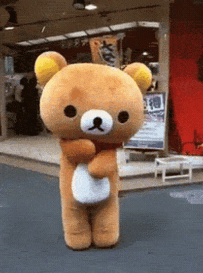 A Teddy Bear Is Standing In Front Of A Store With A Sign That Says ' S ' On It GIF