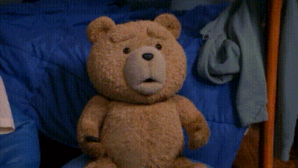 A Teddy Bear Is Standing On A Rug In A Bedroom GIF