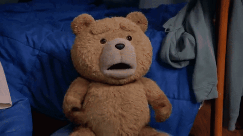 A Teddy Bear Is Standing On A Rug In A Room . GIF