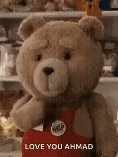 A Teddy Bear Is Wearing A Red Apron And Holding A Heart . GIF