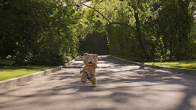 A Teddy Bear Running Down A Road With A Gun GIF