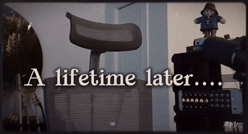 A Teddy Bear Sits On Top Of A Desk With The Words A Lifetime Later GIF