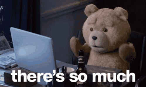 A Teddy Bear Sitting In Front Of A Laptop With The Words " There 'S So Much " Above It GIF