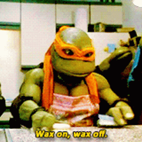 A Teenage Mutant Ninja Turtle Wearing A Pink Apron Says " Wax On Wax Off " GIF