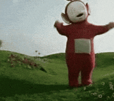 A Teletubbies Character Is Standing In A Grassy Field With His Arms Outstretched GIF