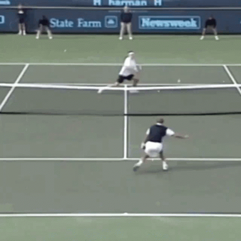A Tennis Game Is Being Played On A Court With A State Farm Banner Behind The Net GIF