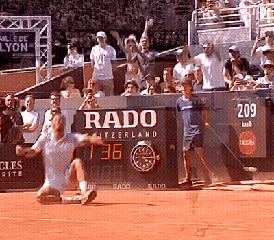 A Tennis Match Is Being Played In Front Of A Rado Sign GIF