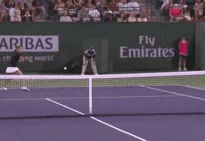 A Tennis Match Is Being Played In Front Of An Ad For Emirates GIF