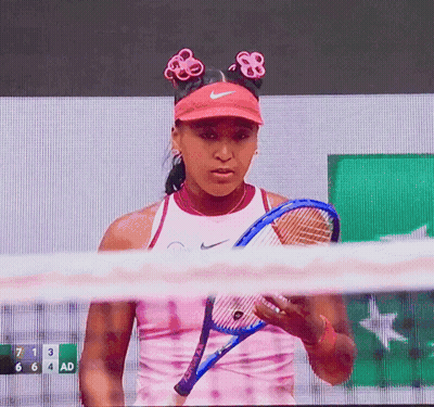 A Tennis Player Holds A Tennis Racquet In Front Of A Scoreboard With The Number 7 On It GIF