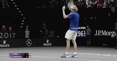 A Tennis Player Holds Up His Racket In Front Of A Sign That Says Rolex GIF