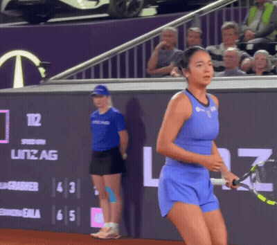 A Tennis Player In A Blue Outfit Is Holding A Tennis Racquet In Front Of A Sign That Says Litz Ag GIF