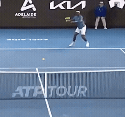 A Tennis Player Is Hitting A Tennis Ball On A Blue Court GIF