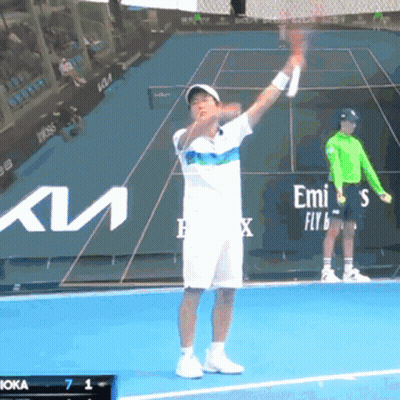 A Tennis Player Is Holding A Racquet On A Court With Emirates In The Background GIF