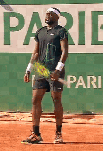 A Tennis Player Is Holding A Tennis Racquet In Front Of A Sign That Says Pari GIF