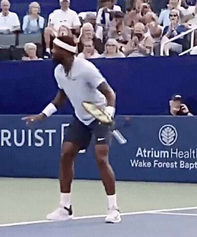 A Tennis Player Is Holding A Tennis Racquet On A Court Sponsored By Atrium Health Wake Forest Baptist Church GIF