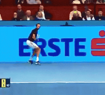 A Tennis Player Is Jumping In Front Of A Large Blue Sign That Says Erste GIF