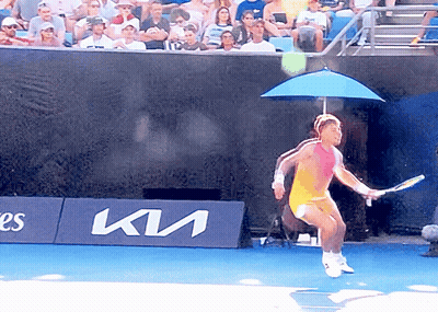 A Tennis Player Is Jumping In The Air In Front Of A Kia Banner GIF