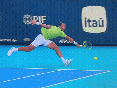 A Tennis Player Is Jumping In The Air While Holding A Racket In Front Of An Advertisement For Itaú GIF