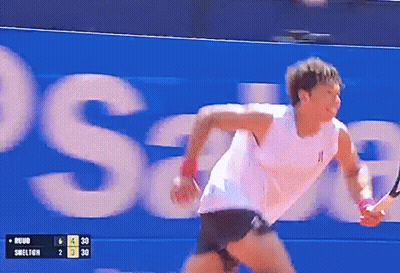 A Tennis Player Is Running In Front Of A Sign That Says Swelton GIF