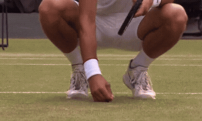 A Tennis Player Is Squatting Down On The Court GIF