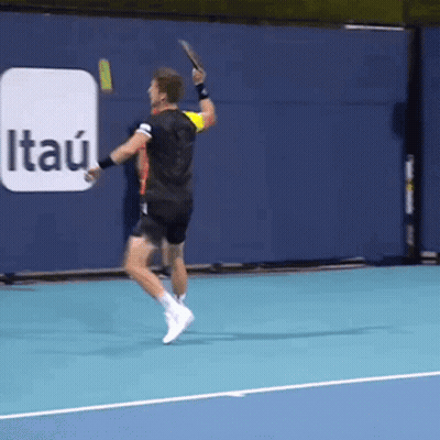 A Tennis Player Is Swinging A Racket On A Court With An Itau Ad In The Background GIF
