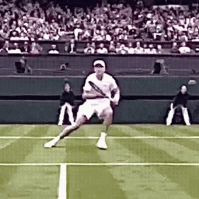 A Tennis Player Is Swinging A Tennis Racquet On A Court GIF