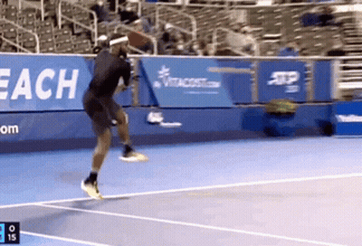 A Tennis Player Jumps In The Air While Playing Tennis GIF