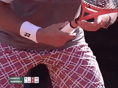 A Tennis Player Named Djokovic Is Holding A Tennis Racquet In His Hand GIF