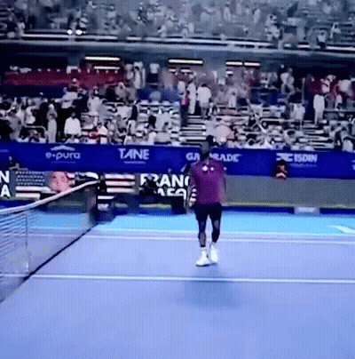 A Tennis Player On A Court With A Banner That Says E Pura GIF