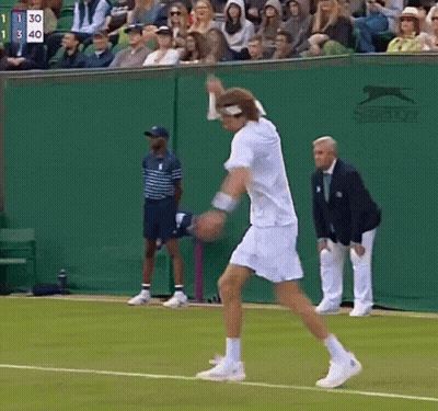 A Tennis Player On A Court With A Slazenger Logo On The Wall Behind Him GIF