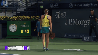 A Tennis Player Stands On A Court With A Rolex Clock In The Background GIF