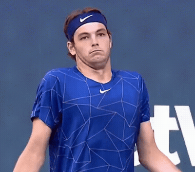 A Tennis Player Wearing A Headband And A Blue Shirt Is Making A Face . GIF