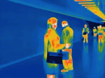 A Thermal Image Of People Walking In A Hallway With A Blue Background GIF