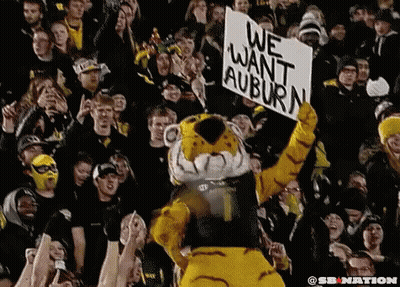 A Tiger Mascot Is Holding Up A Sign That Says We Want Auburn GIF