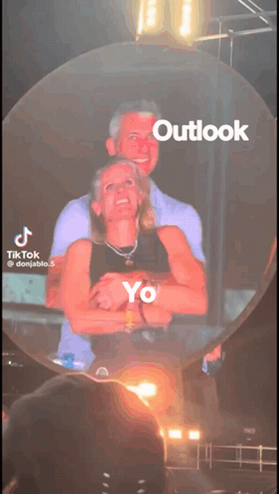 A Tiktok Video Of A Man And Woman Hugging With Outlook Written On The Bottom GIF