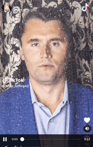 A Tiktok Video Of A Man In A Suit And Blue Shirt GIF